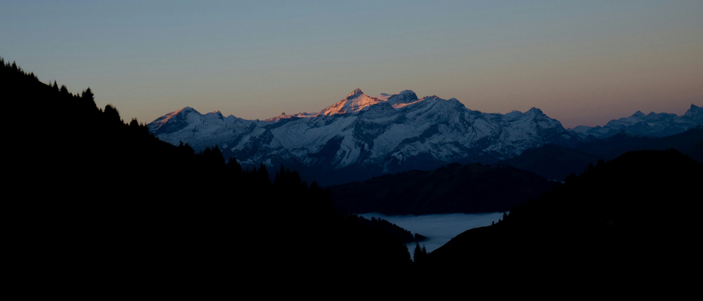 Abendlicht auf den Bergen über dem Nebelmeer im Saanenland